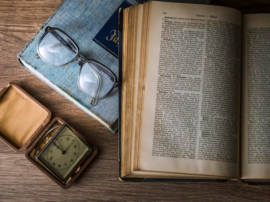 book glasses and clock on a table